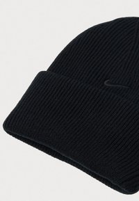 Crna rebrasta pletena kapa s preklopom koja sadrži suptilni izvezeni Nike swoosh logo sa strane.