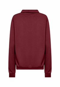 Burgundské crewneck pulovr s dlouhými rukávy, vyrobený z měkké tkaniny. Jednoduchý design s uvolněným střihem a žebrovanými manžetami a lemováním.
