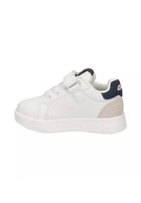 Sneaker bianco con parte superiore in pelle liscia, fascia in velcro e accentuazione in camoscio grigio testurizzato sul tallone. Presenta una suola in gomma e dettagli cuciti.