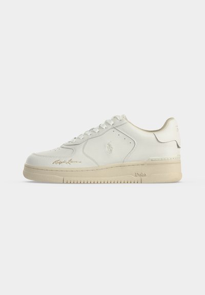 Baskets basses blanches avec semelle beige, design à lacets, logo Polo embossé sur le côté et signature dorée Ralph Lauren près des orteils.