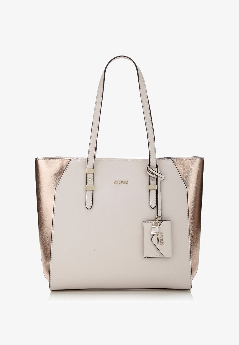 Kangaskassi, jossa on vaaleanbeige etuosa ja metallinhohtoiset rose gold -sivut, kaksinkertaiset olkahihnat ja pieni kiinnitetty tagi avainkoristeella.