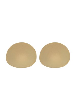 Twee beige siliconen beha-inserts met gladde, afgeronde vormen op een witte achtergrond.
