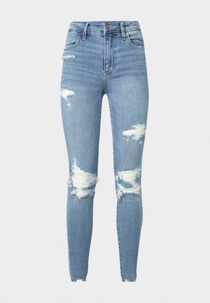 Blugi skinny cu talie înaltă din denim bleu deschis, cu detalii rupte la genunchi și margini desfăcute, având cinci buzunare și închidere cu nasture.