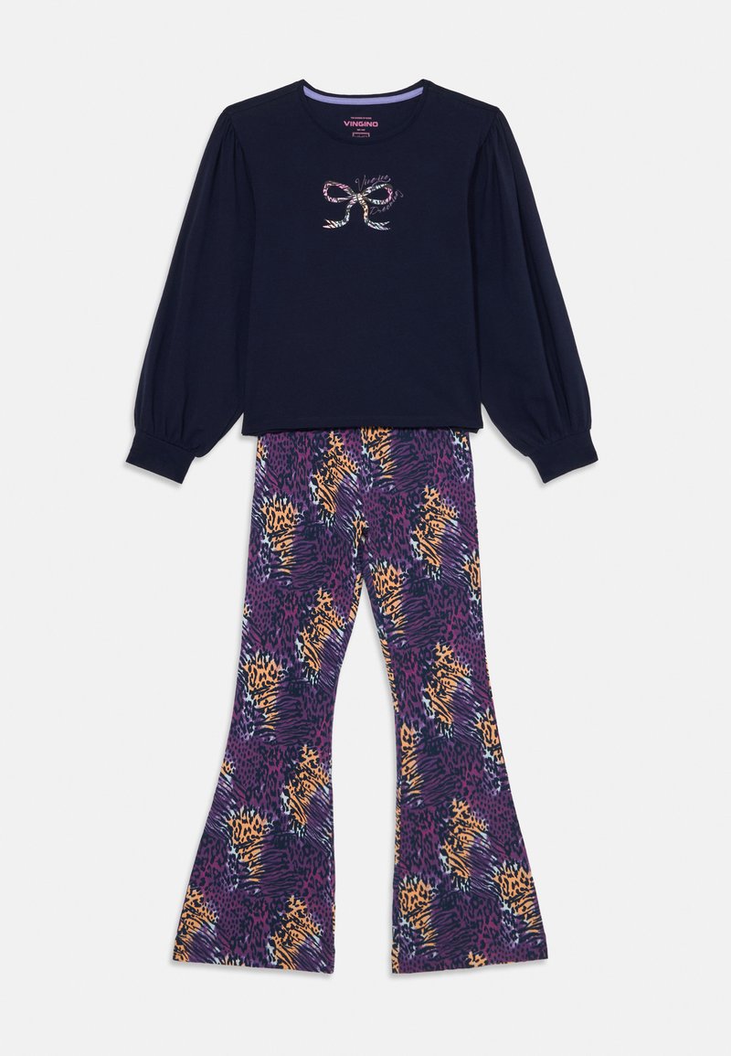 Dlhý rukáv námornícka modrá blúzka s grafickým motívom mašle a rozšírené fialové nohavice so vzorom zvierat v oranžovej a žltej farbe.