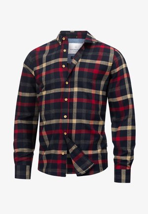 Chemise en flanelle à carreaux rouges, bleu marine et beige, avec un col boutonné, des manches longues et des boutons en bois. Présente un ourlet arrondi.