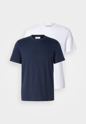 Dwa t-shirty z okrągłym dekoltem w kolorze granatowym i białym, wykonane z bawełny. Oba mają krótkie rękawy i małe logo na lewej piersi.