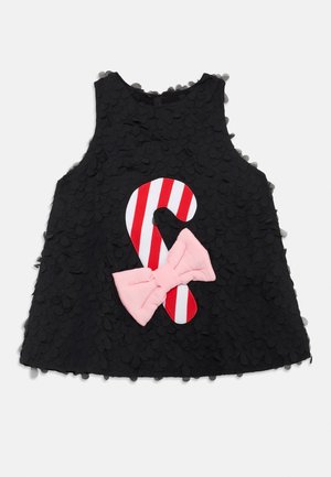 Czarny bezrękawnik z teksturowaną tkaniną o falistym wzorze, ozdobiony czerwono-białym paskowanym lizakiem w kształcie laski oraz dużą różową kokardą z przodu.