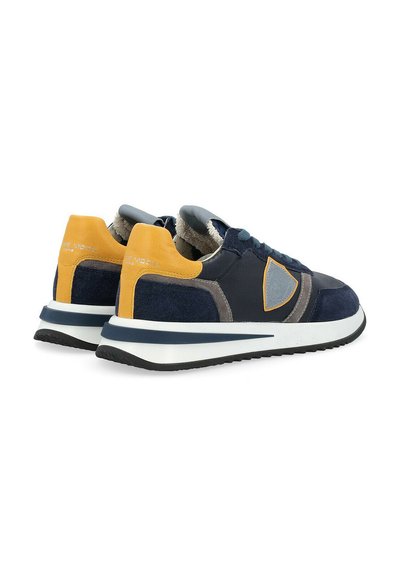 Scarpe da ginnastica blu navy con accenti gialli e grigi. Presentano un mix di pelle e camoscio, suola piatta e design con lacci.