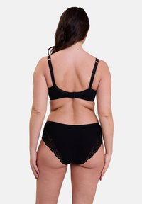 Ensemble de lingerie noir comprenant un bralette lisse avec des bretelles réglables et une culotte taille haute avec des accents en dentelle sur les côtés.