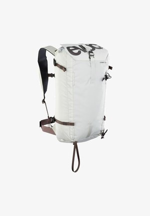 Lichtgrijze rugzak met een oprolbare bovenkant, verstelbare bruine banden en een groot zwart logo; voorzien van zijkompressieriemen en een duurzame afwerking.