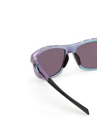 Occhiali da sole con montatura sfumata dal viola al blu, lenti scure e aste nere; presenta dettagli testurizzati ed elementi di design geometrico.