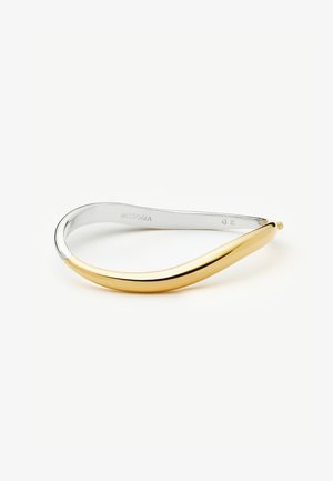 Tofarvet metalarmlænke med glat, buet design; guld på den ene side, der glider over i sølv på den anden, indgraveret med "MISSOMA" indvendigt.