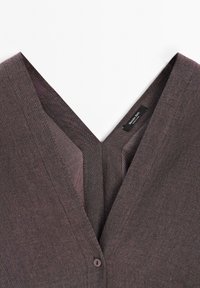 Brauner, strukturierten Stoff V-Ausschnitt Top mit Knopfverschluss an der Vorderseite und einem innen sichtbaren Etikett im Kragen.