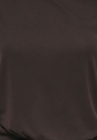 Gros plan sur un tissu lisse brun foncé avec de légers plis et une texture subtile.