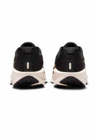 Czarne i brązowe buty sportowe z chropowatą cholewką, amortyzowaną podeszwą i charakterystycznym falistym wzorem na spodzie.