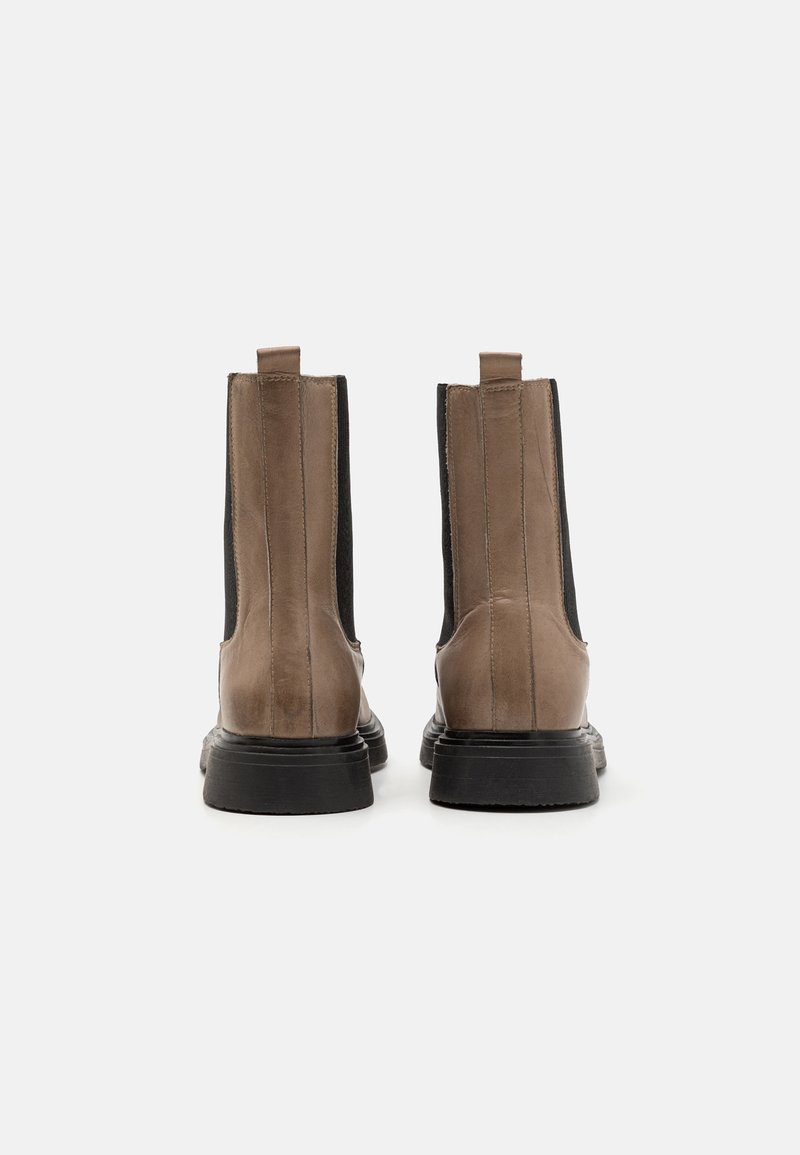 Braune Leder-Stiefeletten mit elastischen Seiteneinsätzen und Zuglaschen, ausgestattet mit einer strukturierten Oberfläche und dicken schwarzen Gummisohlen.