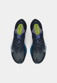 Mørkeblå løpesko med en teksturert overdel, med gradientdesign, svarte lisser og en synlig Nike-logo på siden.