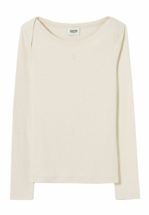 Camicia aderente a maniche lunghe di colore crema con scollatura a barca e discreto logo "CP" centrato sotto il colletto.