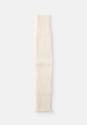 Chauffe-jambes en crème à côtes avec un design tricoté texturé, présentant un revers à une extrémité. Mesure environ 60 cm de longueur.