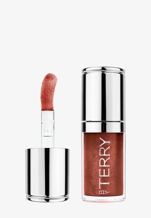 Bruine vloeibare lippenstift met zilveren dop, één tube gesloten en één open met schuine applicator.