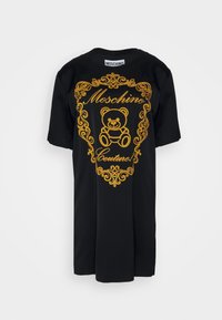 Musta t-paita, jossa on kultapainettu karhun kuvio ja teksti "Moschino Couture", ornamenteilla käytävöity reuna. Lyhyet hihat ja pyöreä kaula-aukko.