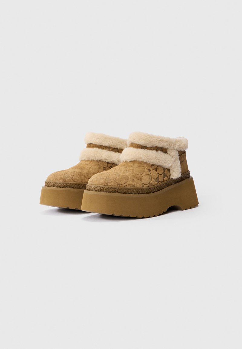 Bruine suède plateauschoenen met een fluffy beige voering en boord, met een textuurpatroon en een dikke, robuuste zool.