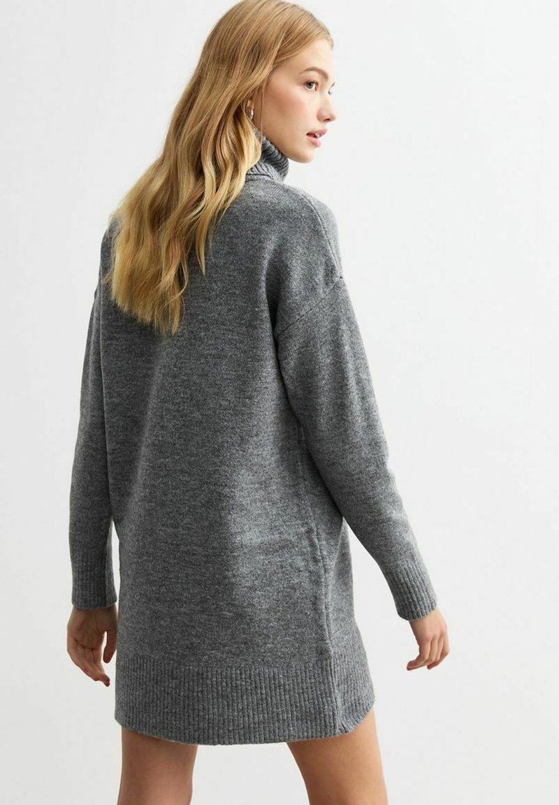 Graues Strickkleid mit hohem Kragen, lockerer Passform und gerippten Bündchen. Weicher Stoff, fällt auf mittlerer Oberschenkelhöhe am Rücken, lässiges Design.