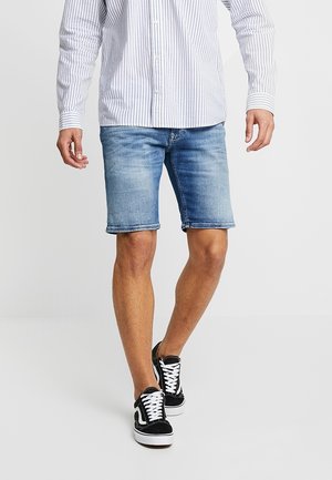 Denim shorts in light blue with a faded finish, featuring a straight cut, rolled hem, and five-pocket design, paired with black sneakers.