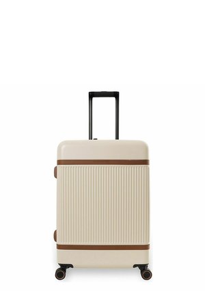 Beige kovakuorinen matkalaukku pystysuuntaisilla urilla, ruskeilla vaakasuorilla korostuksilla, neljillä pyörillä ja vedettävällä mustalla kahvalla.