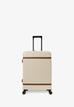 Beiger Hartschalenkoffer mit vertikalen Rillen, braunen horizontalen Akzenten, vier Rädern und ausgezogenem schwarzem Teleskopgriff.