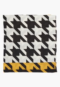 Écharpe à grand motif pied-de-poule noir et blanc avec une bordure pied-de-poule jaune moutarde et noire le long d'un bord.