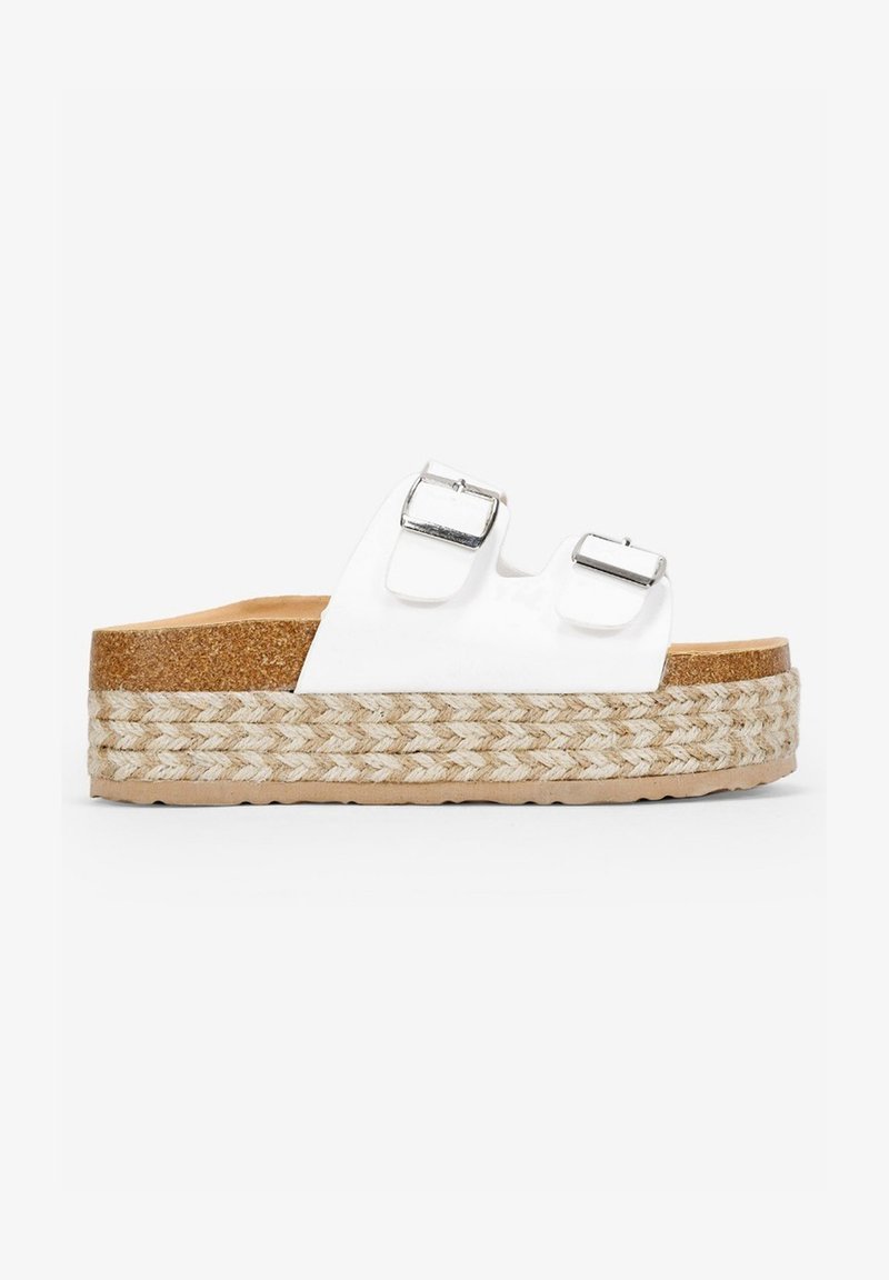 White platform sandal with two adjustable silver buckle straps, woven jute-like sole, and textured cork insole.