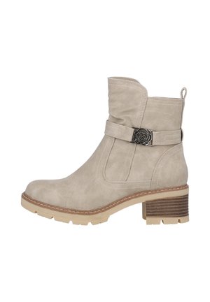 Beige ruskind ankelstøvle med dekorativ rem og blomstret metalspænde, stablet hæl og robust sål.