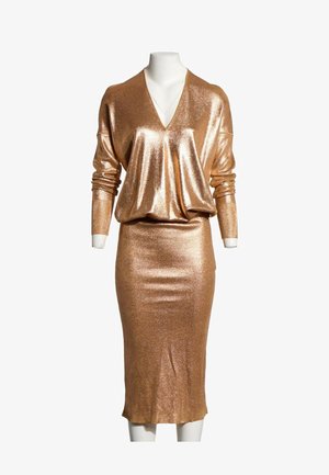 Robe longue à manches longues métallique dorée brillante avec haut à col en V et jupe crayon ajustée sur un mannequin sans tête sur fond blanc.