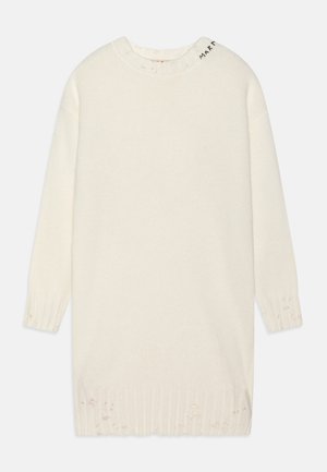 Robe en maille écrue à manches longues avec des détails usés aux poignets et à l'ourlet, arborant un petit texte noir près de l'encolure.