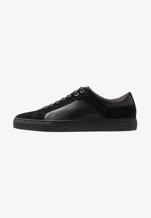 Sneaker neri realizzati in un mix di pelle e camoscio, con un design low-top, chiusura con lacci e suola in gomma con un motivo testurizzato.