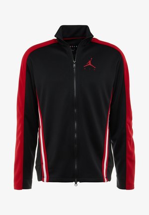 Veste zippée noire et rouge avec manches rouges, bandes latérales blanches et rouges, et logo Jumpman rouge sur la poitrine gauche.