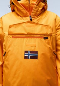 Oranžová větrovka s kapsou na zip na hrudi, nastavitelnou kapucí a nášivkou s norskou vlajkou. Hladký, voděodolný materiál.