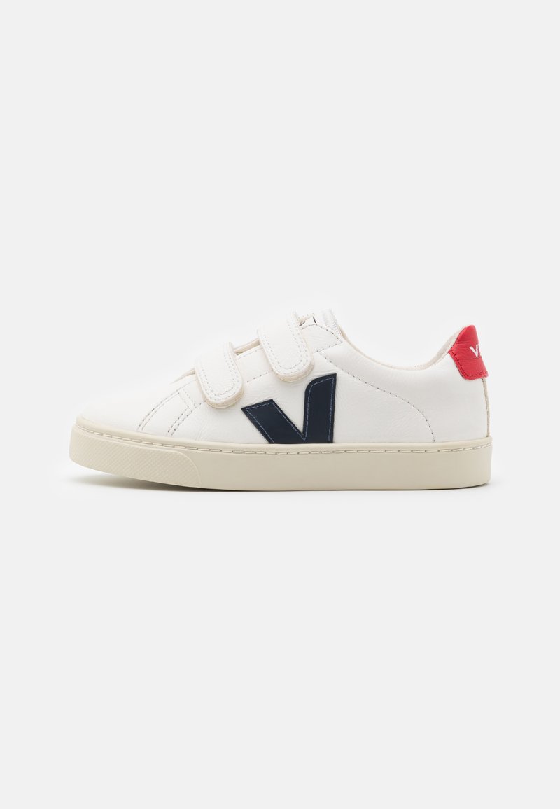 Witte leren sneakers met een marineblauw "V" logo, klittenbandsluitingen, beige rubberen zool en een rode accent op de hak.