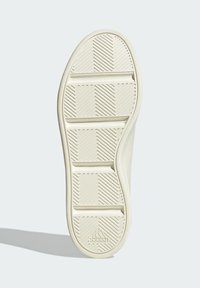 Tenisica boje kreme s potplatom koji sadrži teksturirani, uzorčast grip dizajn s horizontalnim i dijagonalnim utorima za bolju prionljivost.