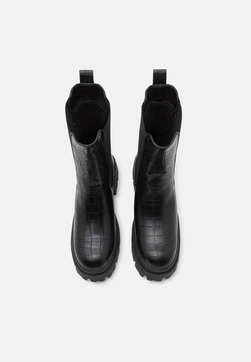 Stivaletti neri alla caviglia con texture in coccodrillo, dotati di una fodera in pelliccia, pannelli laterali elasticizzati e una suola in gomma spessa per una migliore aderenza.