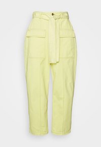 Pantalones amarillos de cintura alta con bolsillos frontales de solapa, un cinturón de tela a juego anudado en la cintura y un cierre de botón.