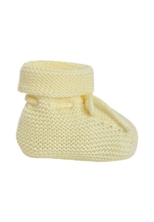 Chausson bébé jaune doux en tricot avec bord replié et détail de lien latéral sur fond blanc.