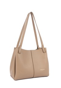 Sac fourre-tout en cuir beige avec doubles anses d'épaule, texture grainée et petit logo doré "Lancaster Paris" en bas à droite sur le devant.