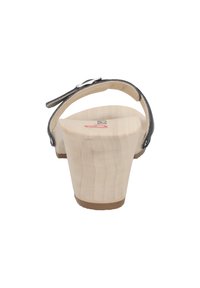 Holzplattform-Sandalette mit einem metallicfarbenen Riemen, abgerundetem offenen Fersenbereich und einem glatten beigen Fußbett. Minimalistisches Design mit natürlicher Oberfläche.
