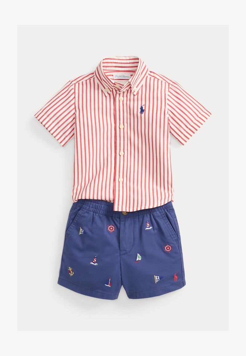 Κοντομάνικο πουκάμισο με κόκκινες και λευκές ρίγες και κουμπιά, συνδυασμένο με μπλε σορτς που διαθέτει κεντημένα ναυτικά σύμβολα και ελαστική μέση.
