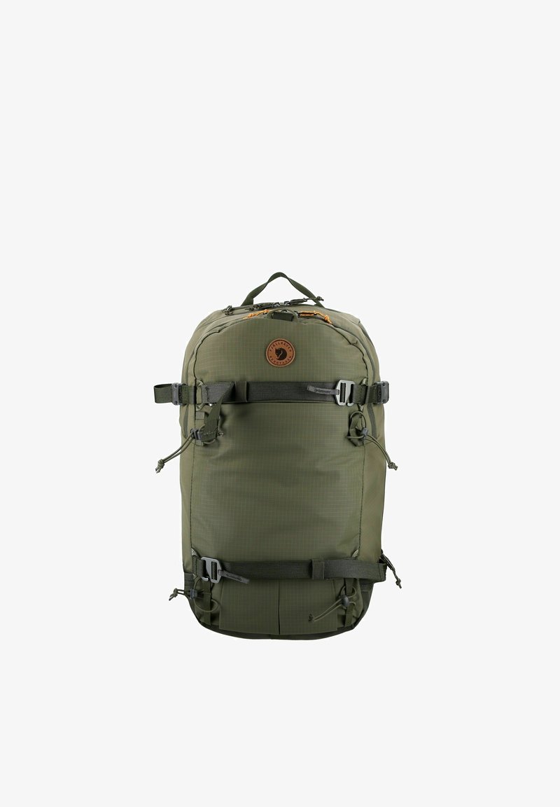 Olivgrüner Rucksack aus strapazierfähigem Stoff mit abgerundeter Form, verstellbaren Gurten, robusten Reißverschlüssen und einem runden Logo-Patch.