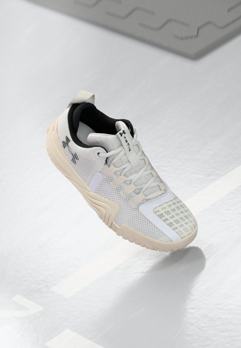 Weiße Sportschuh mit einer strukturierten Mesh-Oberfläche, einem schwarzen Innenraum und einer beigen Gummisohle mit einem gemusterten Grip. Akzentuiert durch subtile Details.