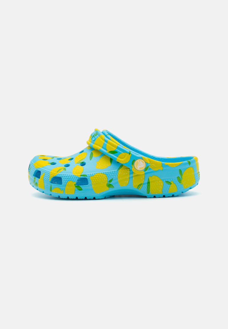 Tamancos azuis com padrões de limão amarelo, feitos de material leve. Apresentam orifícios de ventilação e uma alça para um ajuste seguro.