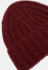 Berretto a maglia bordeaux con una finitura morbida e testurizzata e motivo a coste verticali. Risvolto nella parte inferiore per ulteriore calore.